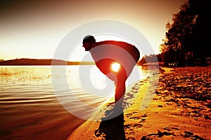 Sport active man running and exercising on the beach at sunset.