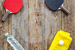 Sport background. Traning cocept. Ping pong racket, towel and water on wooden background top view copyspace