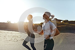 Sport On Beach. Running Couple In Fashion Sportswear On Morning Workout. Sexy Man And Beautiful Woman Jogging.