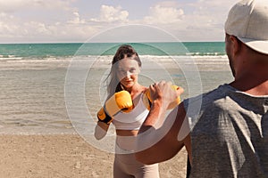 Sport beautiful woman boxer training and punching yellow glove mitt to her trainer, sport people doing exercise and training