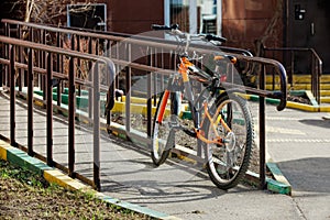 A sport bike is tied to the fence on a sunny day in spring and summer.