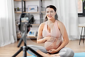 Happy pregnant woman blogger recording yoga video