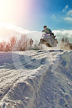 Sport blue snowmobile jump. Clear sunny winter day. Concept quick movement. Extreme sport background for any purposes. photo