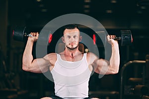 Sport, bodybuilding, weightlifting, lifestyle and people concept - young man with dumbbells flexing muscles in gym