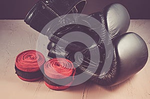 Sport and boxing concept/black boxing gloves and red bandage