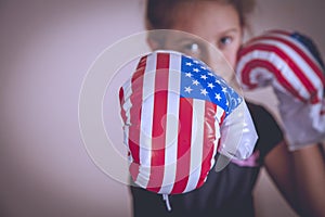 Sport and boxing concept. Portrait of young cute girl fighter with boxing gloves in flag of USA