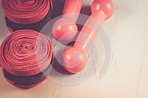Sport and boxing concept with red dumbbells and bandage/sport and boxing concept with red dumbbells and bandage on a white stone