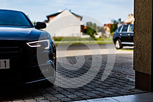 Sport car parks on driveway on friendly neighborhood