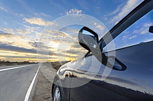 Sport car on the straight road and colorful bright sunset sky