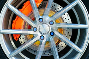 Sport car wheel and orange brake caliper , Blue wheel nut