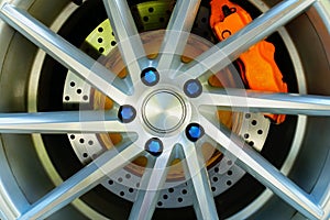 Sport car wheel and orange brake caliper , Blue wheel nut