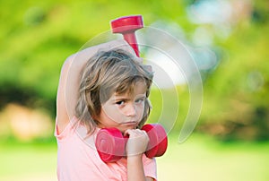 Sport child boy with strong biceps muscles. Kids exercising fitness dumbbells. Strong little boy exercising with