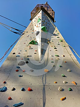 A sport climbing wall with a platform on top. Perspective view from below