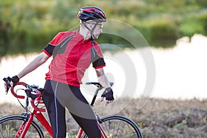 Sport Concepts. Male Cyclist Resting Outdoors on His Bike on Nature Background With Professional Outfit