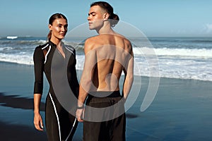 Sport Couple On Beach Portrait. Handsome Shirtless Man And Sexy Woman In Fashion Sporty Outfit Posing.