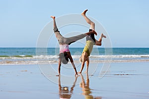 Sport couple doing gymnastics on the beach