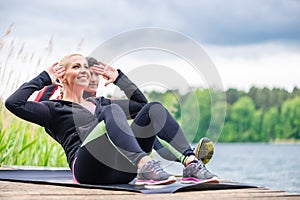 Sport couple doing sit-ups outdoor at river