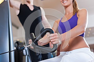 Sport - couple is exercising on machines in gym
