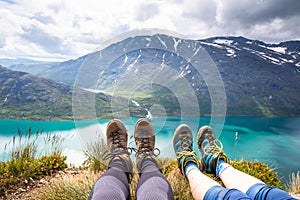 Sport couple hiking on Besseggen. Hikers enjoy beautiful lake and good weather in Norway.