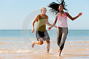 Sport couple jogging on the beach