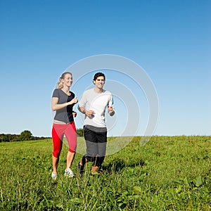 Sport couple jogging outdoors in summer