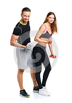 Sport couple - man and woman with dumbbells on the white