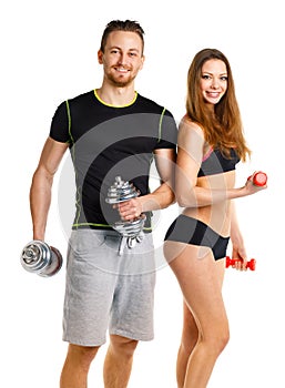 Sport couple - man and woman with dumbbells on the white