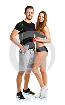 Sport couple - man and woman with dumbbells on the white