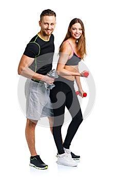 Sport couple - man and woman with dumbbells on the white