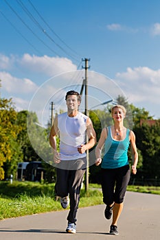 Sport couple running and jogging on rural street