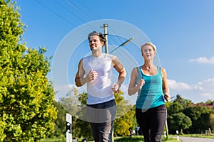 Sport couple running and jogging on rural street