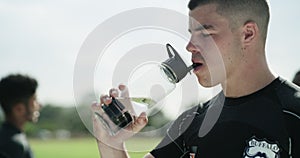 Sport, exercise or athlete in drinking water in stadium, thirsty or rugby commitment for training. Man, drink and health