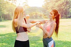 Sport exercise personal trainer teaching student to warm up and stretching her arm and shoulder