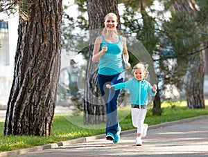Sport family. Mother and baby daughter jogging run on nature