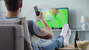 Sport fan watching recording of missed soccer match, modern smart tv technology