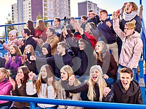 Sport fans clapping and singing on tribunes photo