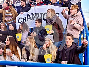 Sport fans holding champion banner on tribunes
