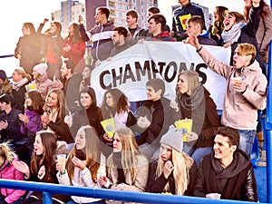 Sport fans holding champion banner on tribunes