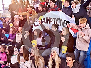 Sport fans holding champion banner on tribunes.