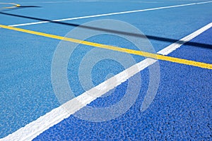 Sport field court background. Blue rubberized and granulated ground surface with white, yellow lines on ground. Top view