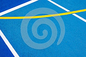 Sport field court background. Blue rubberized and granulated ground surface with white, yellow lines on ground. Top view