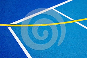Sport field court background. Blue rubberized and granulated ground surface with white, yellow lines on ground. Top view