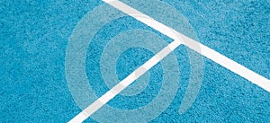 Sport field court background. Light blue rubberized and granulated ground surface with white lines. Top view