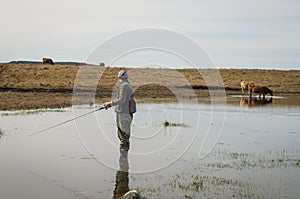 Sport fisherman fishing in lake on cloudy day