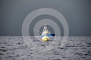 sport fishing boat in the ocean behind a buoy