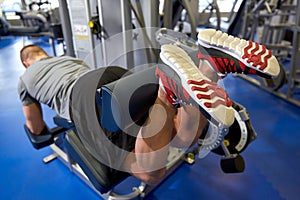 Man flexing leg muscles on gym machine