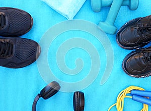 Sport fitness concept, space for text, black sneakers, blue dumbbells, headphones, fitness jump rope template