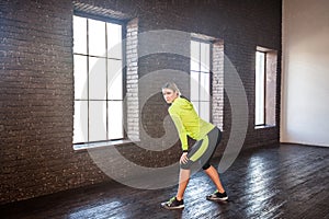 Sport, fitness concept. Woman in sportswear posing near brick wa