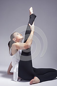 Sport and Fitness Concepts. Caucasian Sexy Female Athlete In Good Fit Doing Leg and Hands Stretching Exercises in Gym