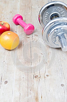 Sport fitness diet concept weights dumbbell and fruit